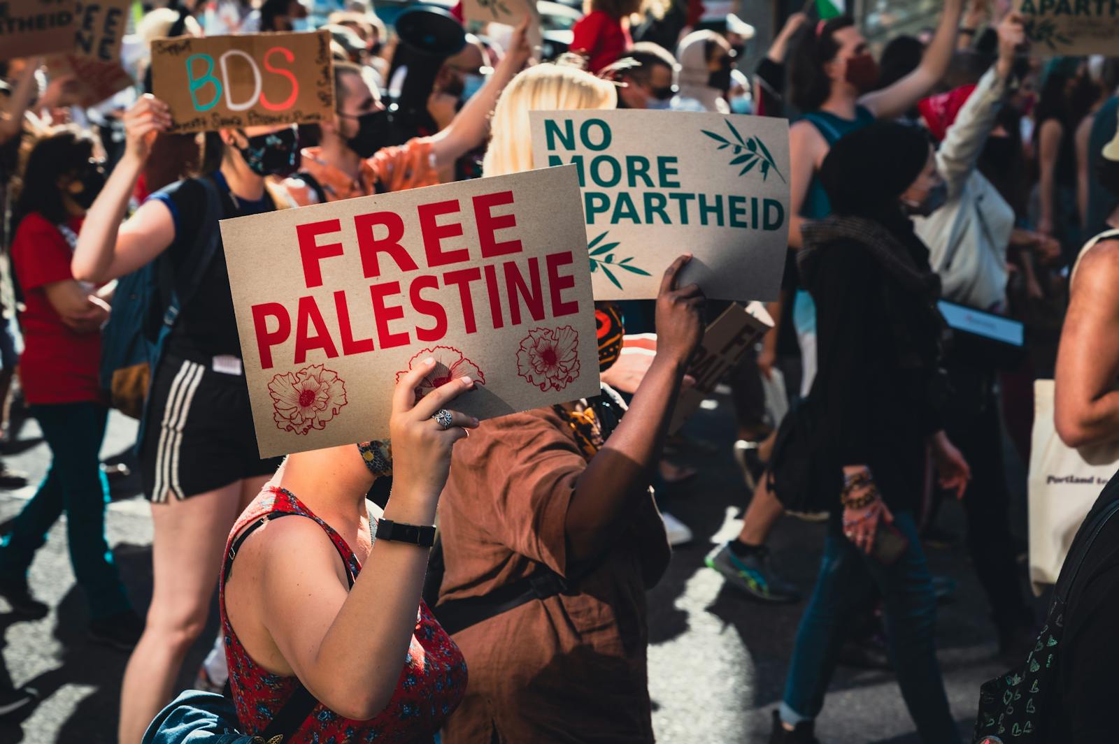 A dynamic protest rally advocating for Palestinian rights with active participants and clear signage.